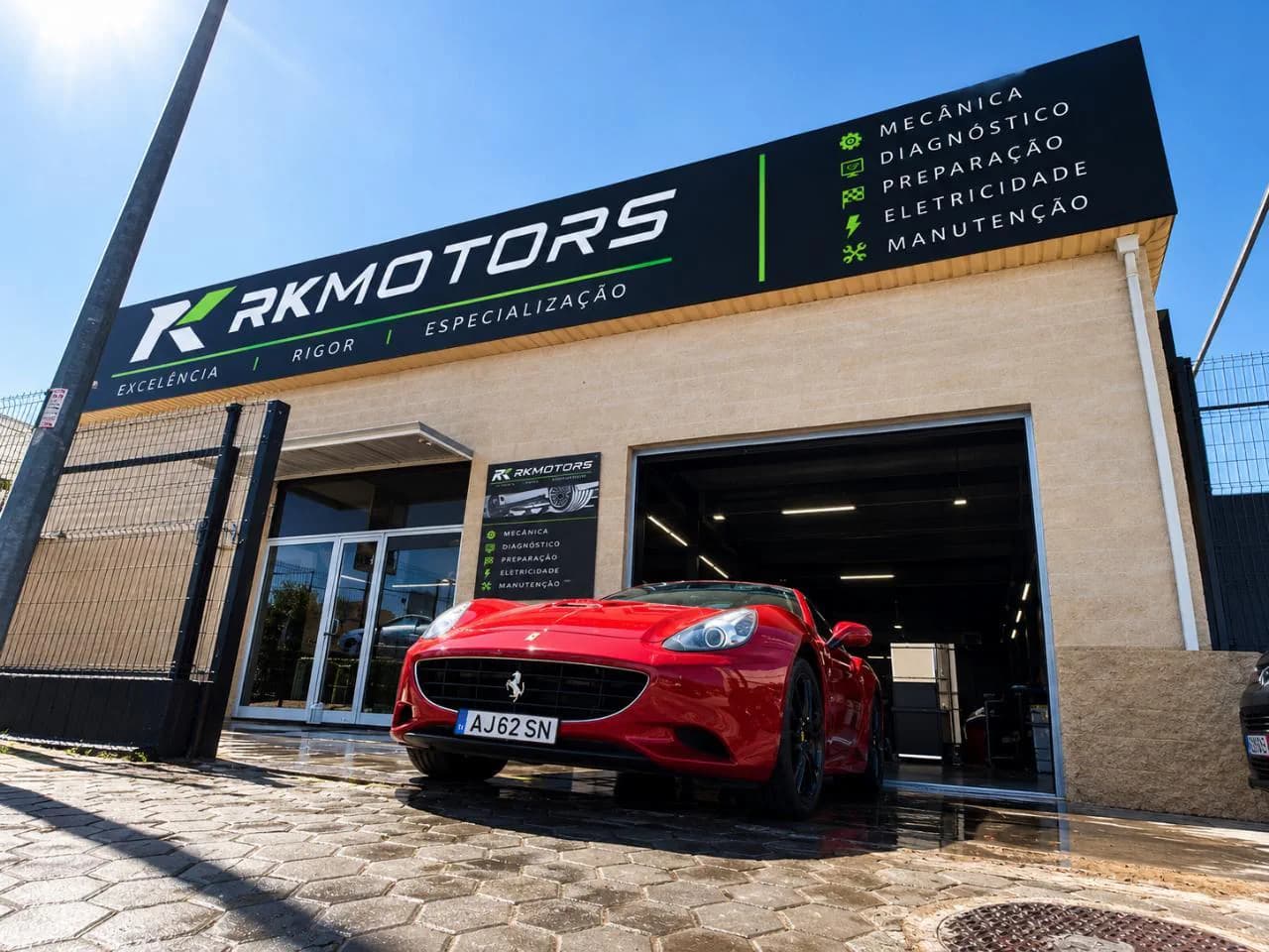 Fachada da RKMotors no Parchal, com o letreiro dos serviços e um Ferrari California vermelho à entrada da oficina
