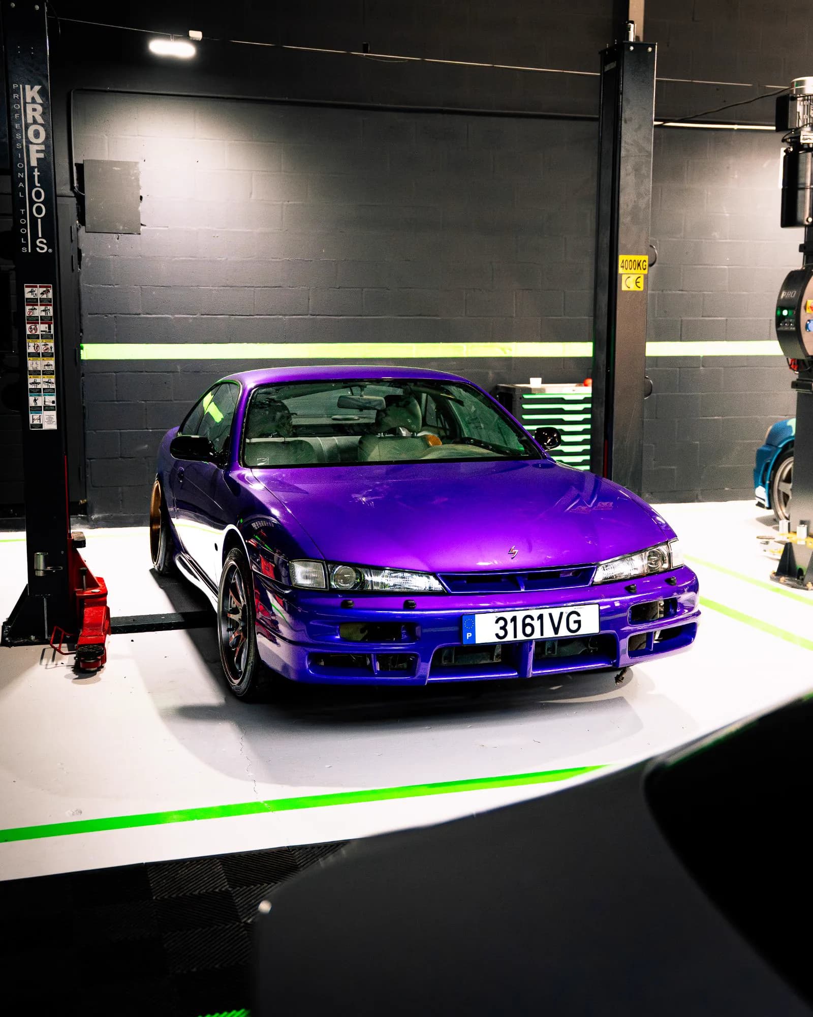 Nissan Silvia S14 roxo de frente, entre as colunas de um elevador