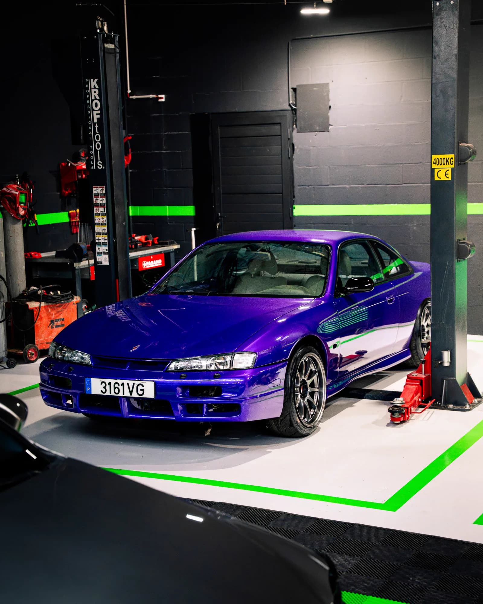 Nissan Silvia S14 roxo visto de lado no elevador da oficina